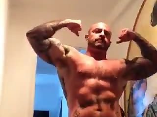 Inked muscular dilf flexes with his big cock out